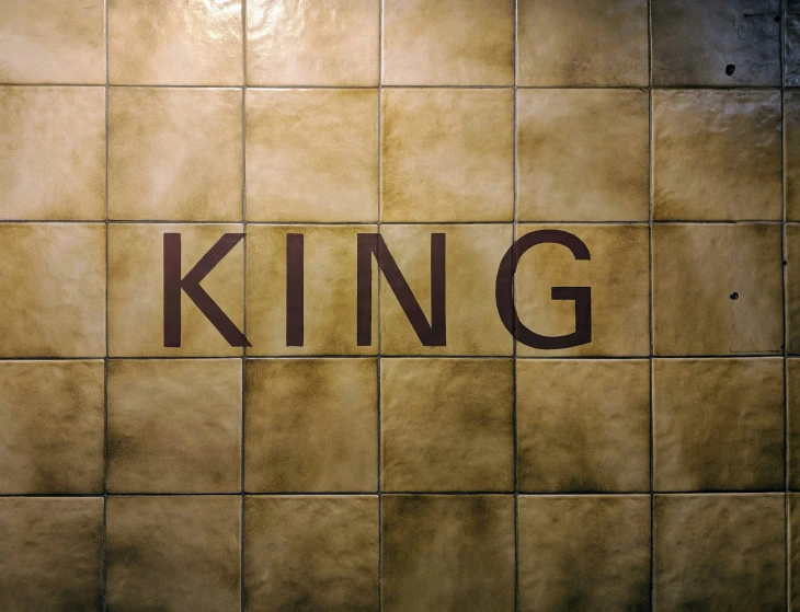 a tiled wall with the word king written on it