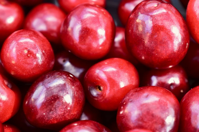 a pile of red apples sitting on top of each other