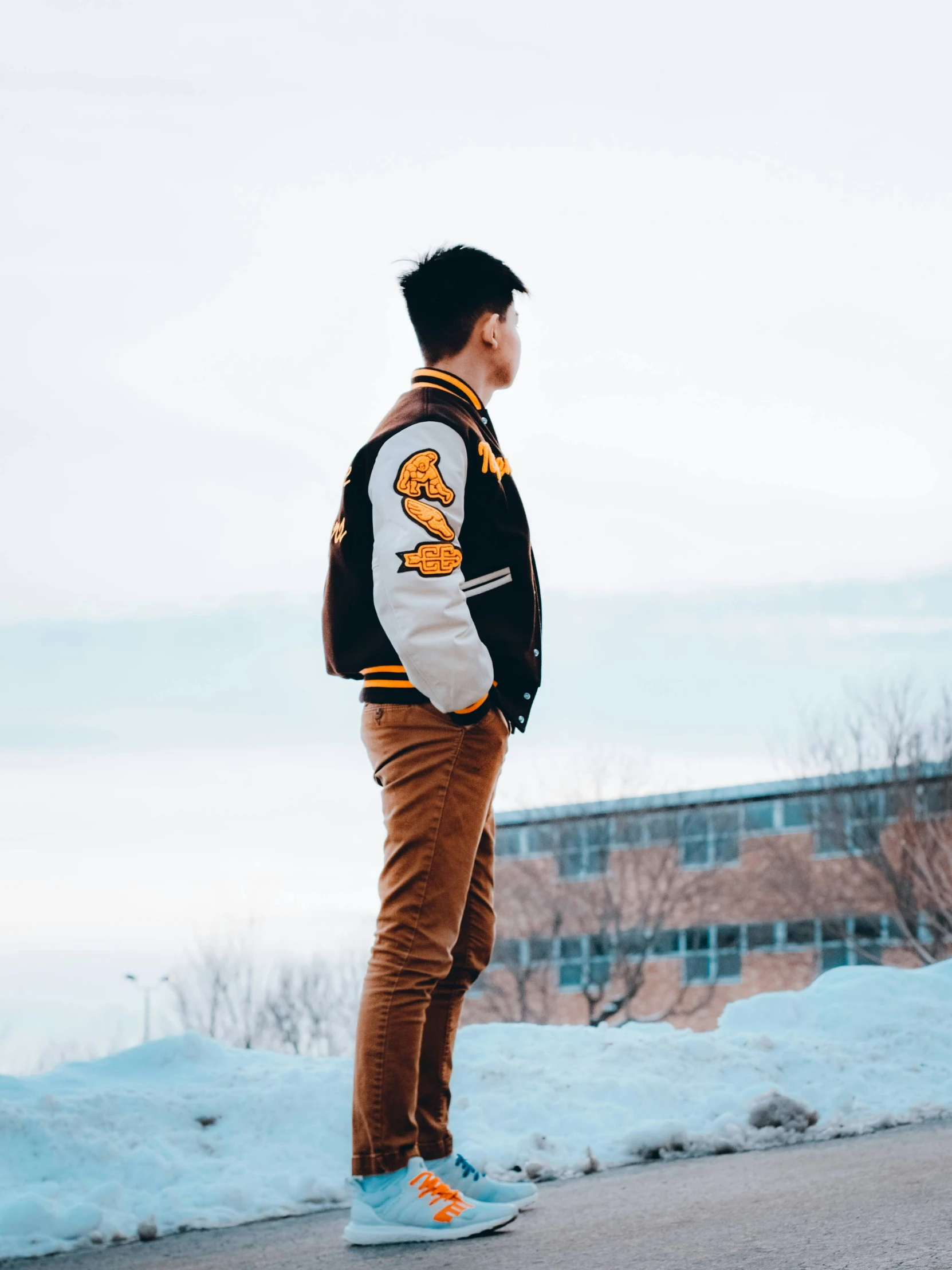 man in striped jacket and sneakers posing for the camera