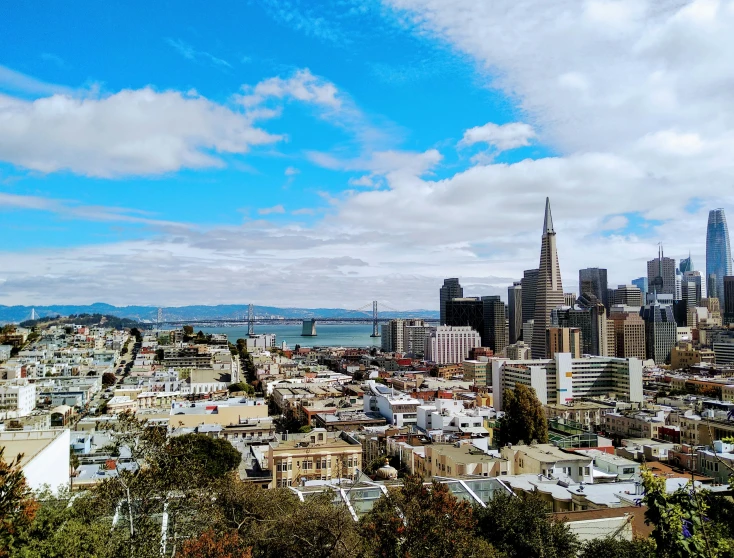 an aerial view of city buildings and the water in the distance