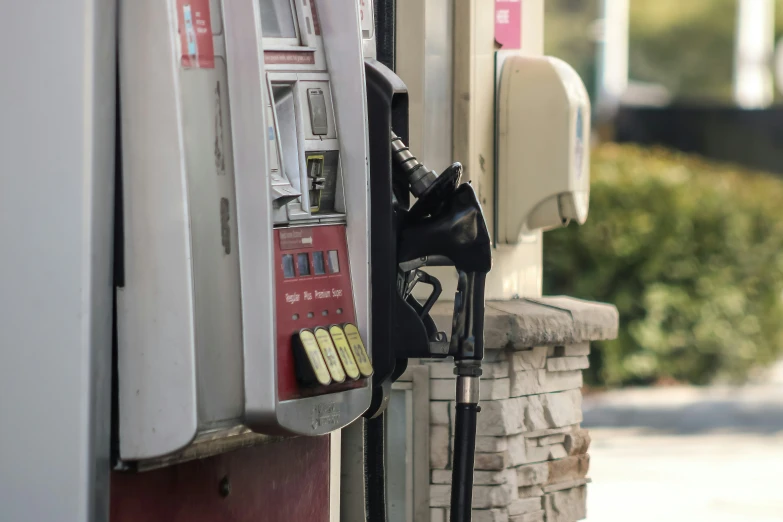 a gas pump near some stones on the sidewalk