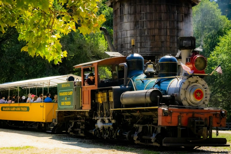 train with tourists riding along the tracks at a attraction park