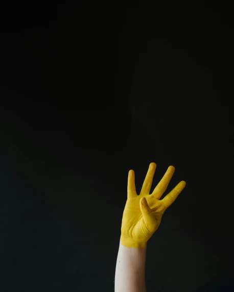 two hands wearing yellow gloves and holding their hands out