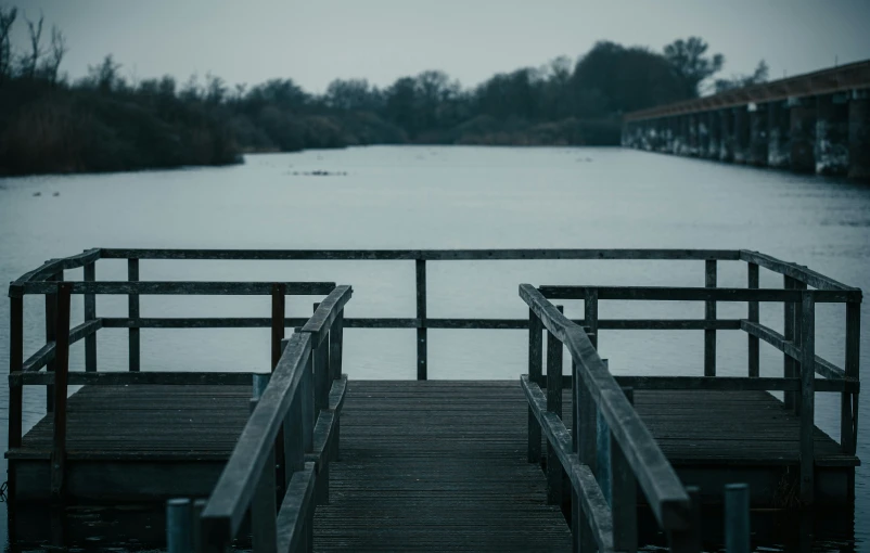 two wooden steps going over a bridge into the water