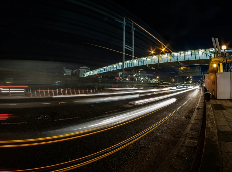 some cars going under a lit overpass at night