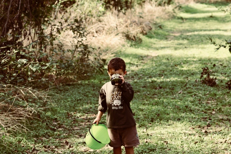 a small boy is holding a frisbee near the grass