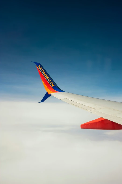 the underside of an airplane's wing on a blue sky day