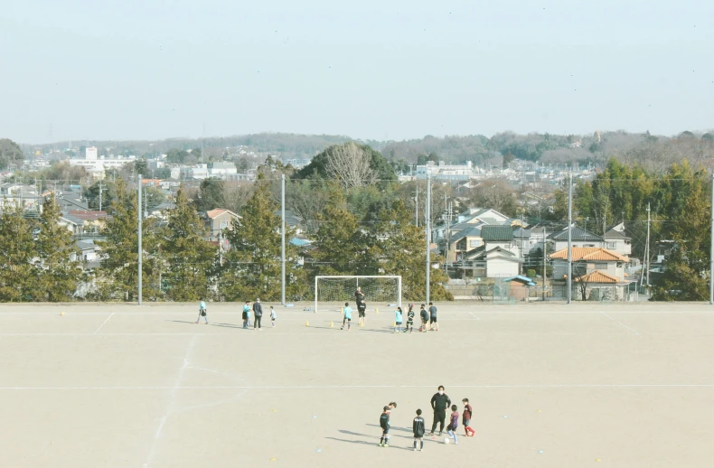 soccer goal on a open field surrounded by buildings