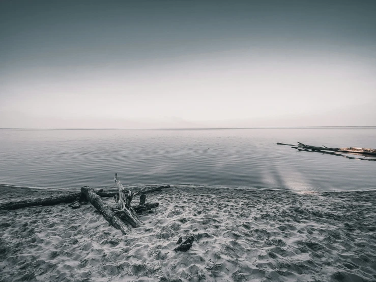 a sandy beach in front of an ocean and a sky