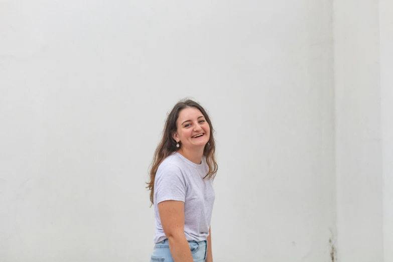 a woman standing in front of a wall smiling