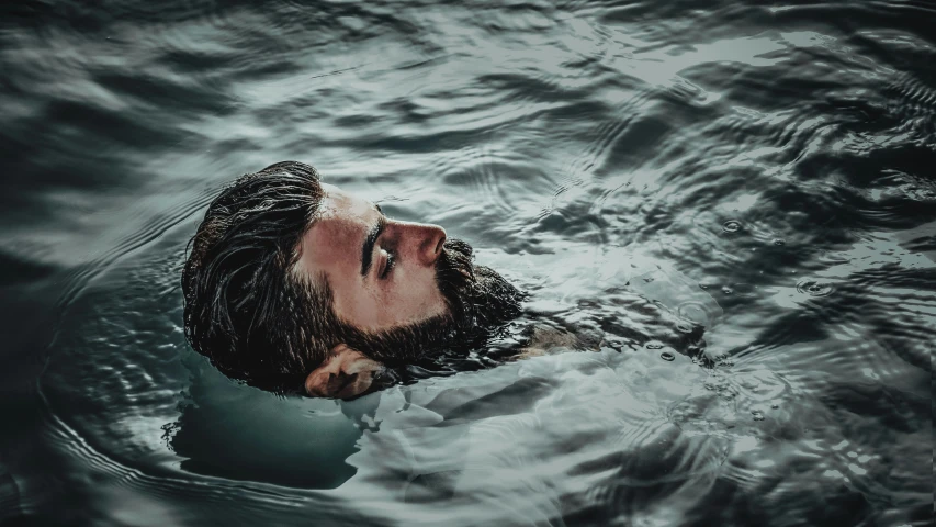 a man in a body of water with his head above the water