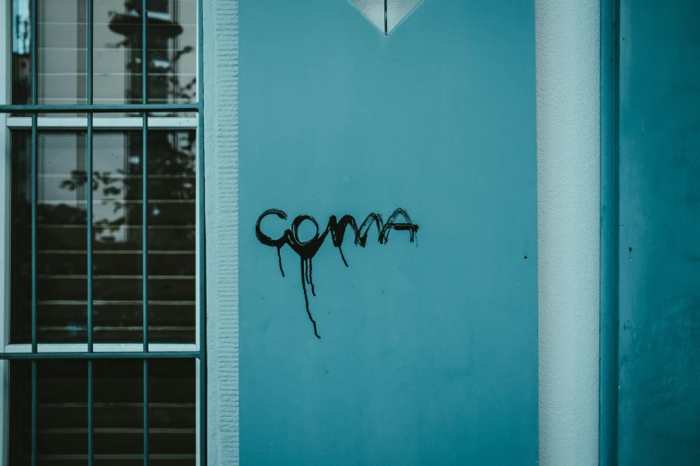 graffiti sprayed on the side of a wall near windows