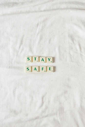 an uncoupered blanket with scrabble letters spelling stay safe