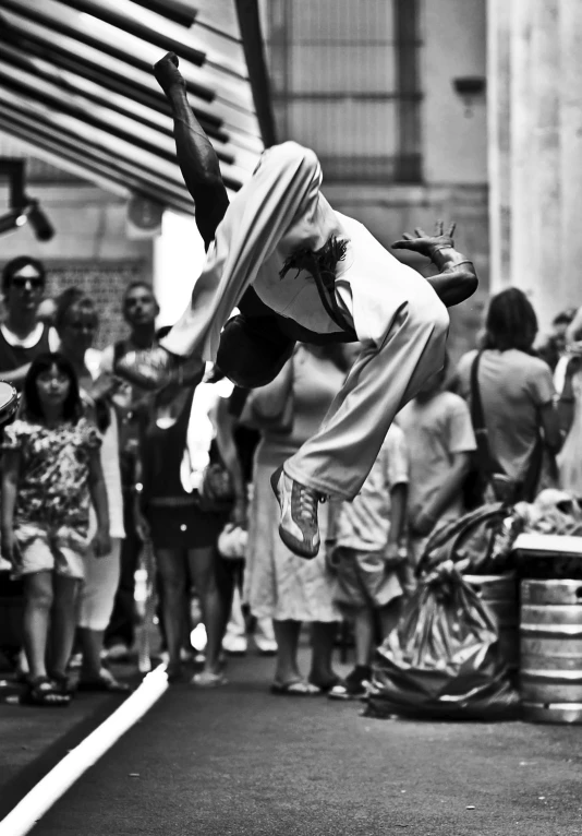 a person on a street doing tricks in front of a crowd