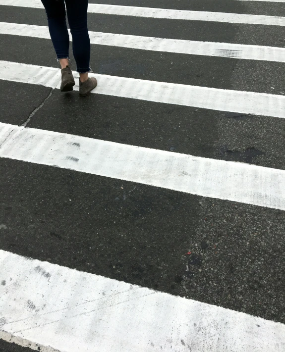 a person with an umbrella is crossing the street