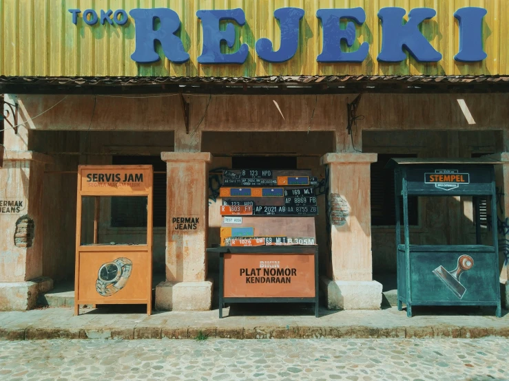 this is an empty sidewalk with a newspaper rack and a building that says, today's reuveni