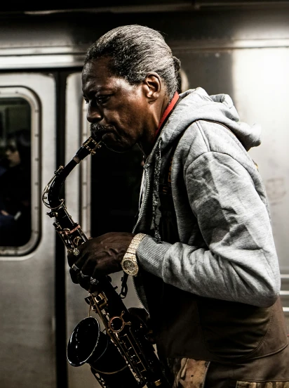 a man is playing his saxophone in a train