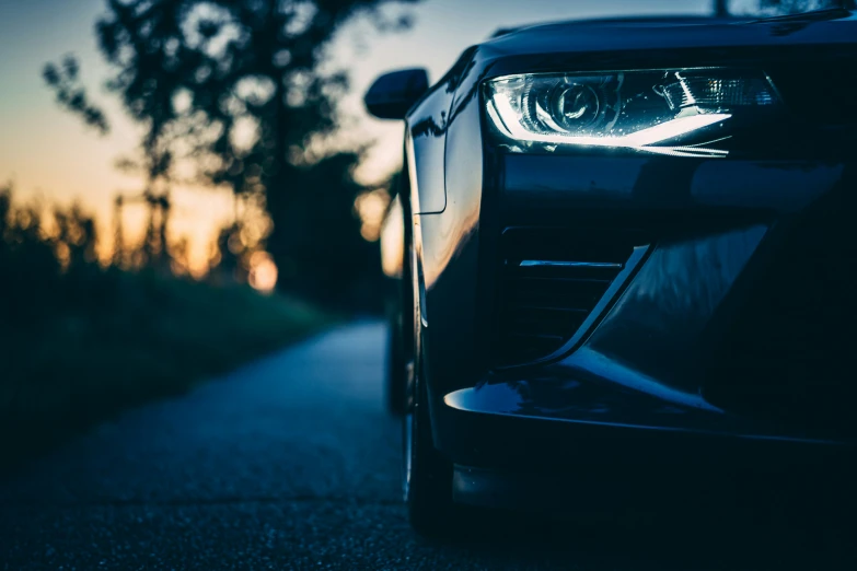 the front end of a parked car at sunset