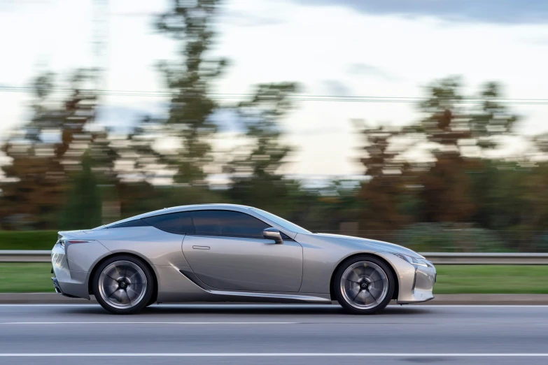 the very sleek looking sports car is driving on the road
