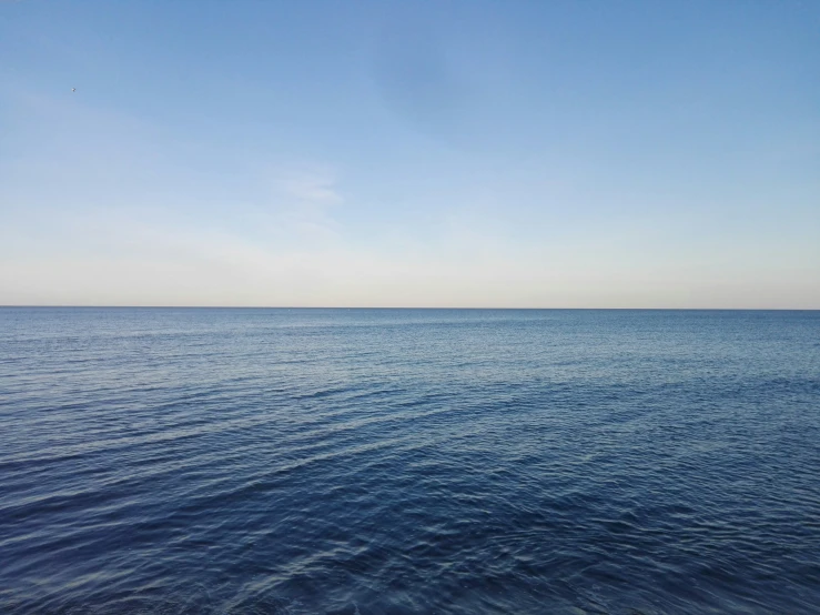 a body of water with a sky and clouds in the background