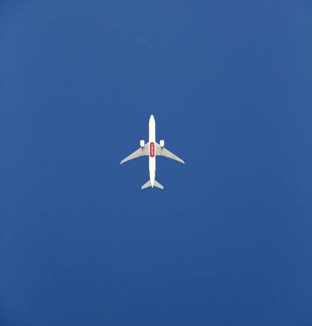 an airplane flying high in the air on a clear day