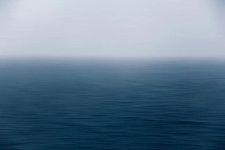 a long row of boats floating on top of the ocean