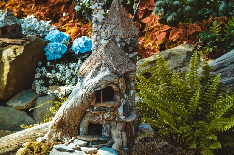 a small clay building on a rock garden path