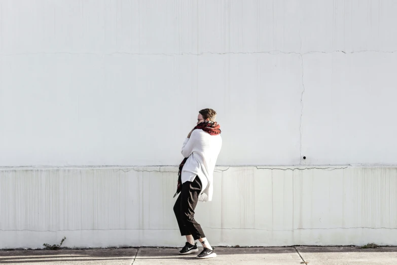 a young woman is standing on the sidewalk outside