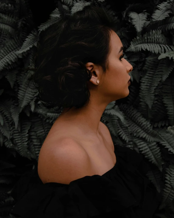 a beautiful woman standing in front of some plants