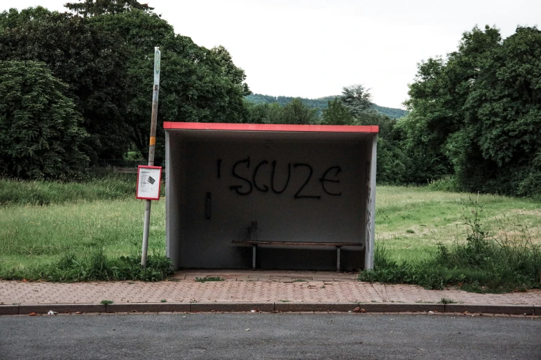 a bench under a shelter sitting on the side of a road