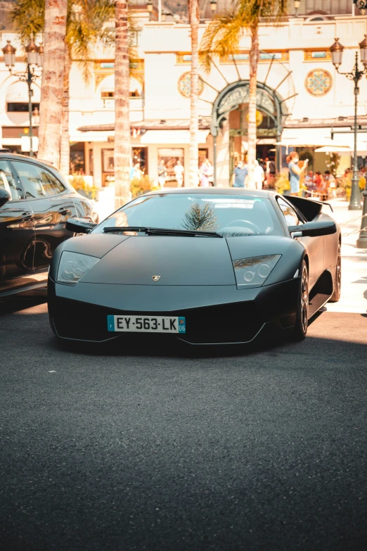 a black sport car and a silver sports car on a street