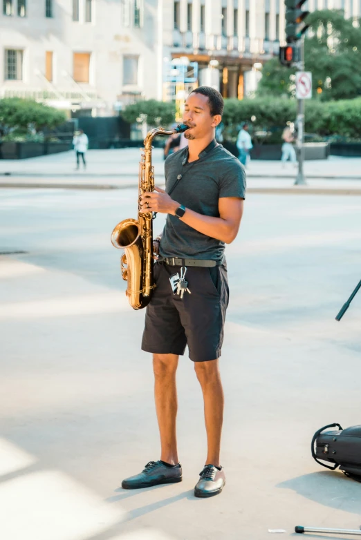 a man is standing outside with his saxophone