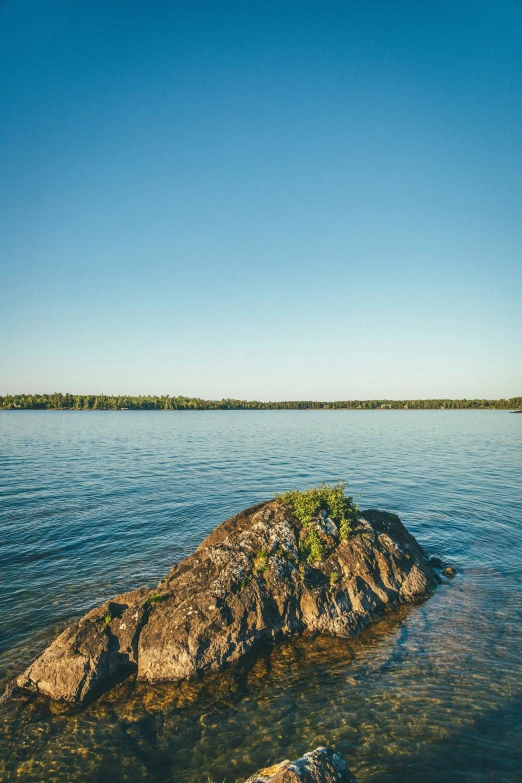 an island sits on a small rock in the middle of the water