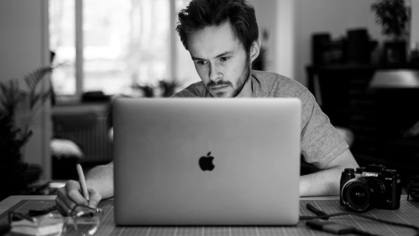 the man is looking at the screen of his laptop