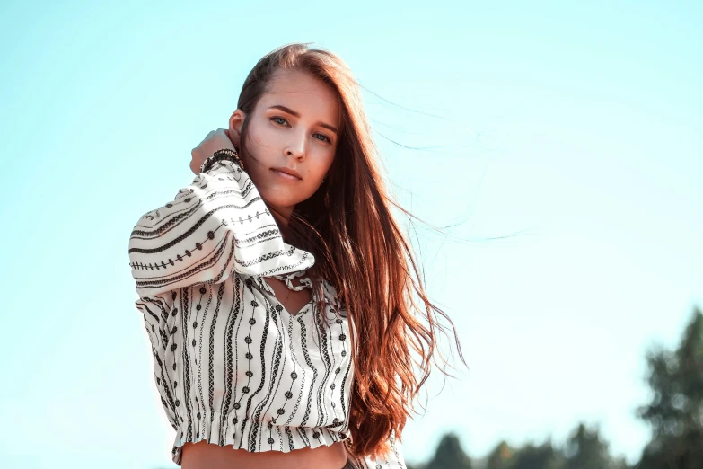 young woman in a striped blouse posing for a camera