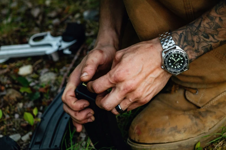 a man wearing a watch on his wrist and fixing his bike tire