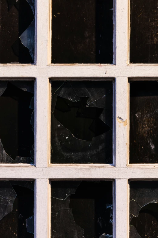 an old broken window frame with some broken glass