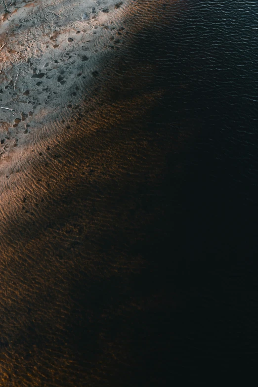 view of dirt shoreline from the air at a beach