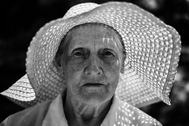 an older woman wearing a hat in black and white