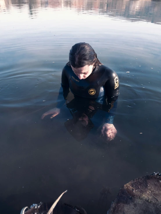 a person standing in the water, looking at soing