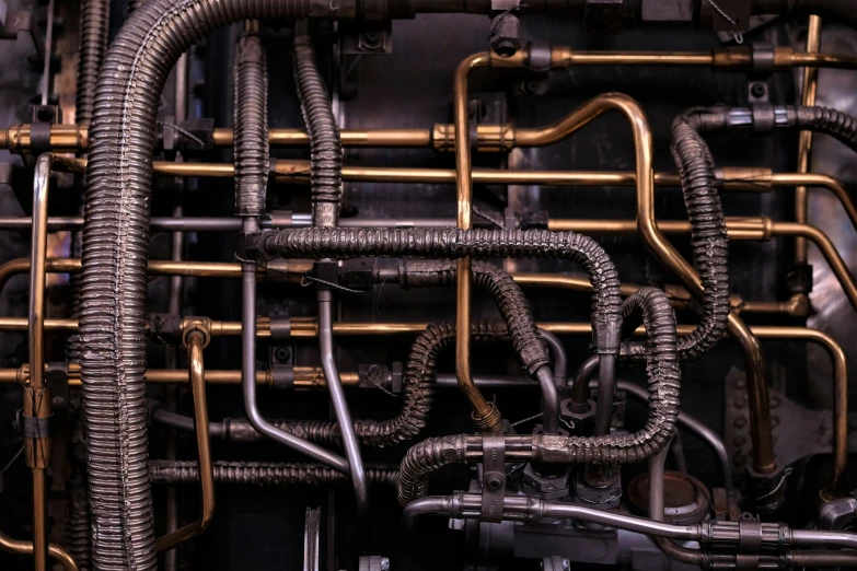 multiple metal pipes and wires against a black background