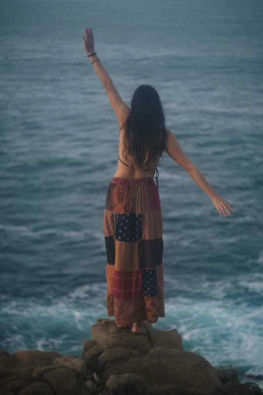 a woman that is standing on top of a cliff