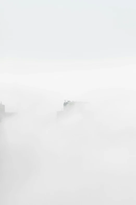 three vehicles parked on top of a hill in the fog