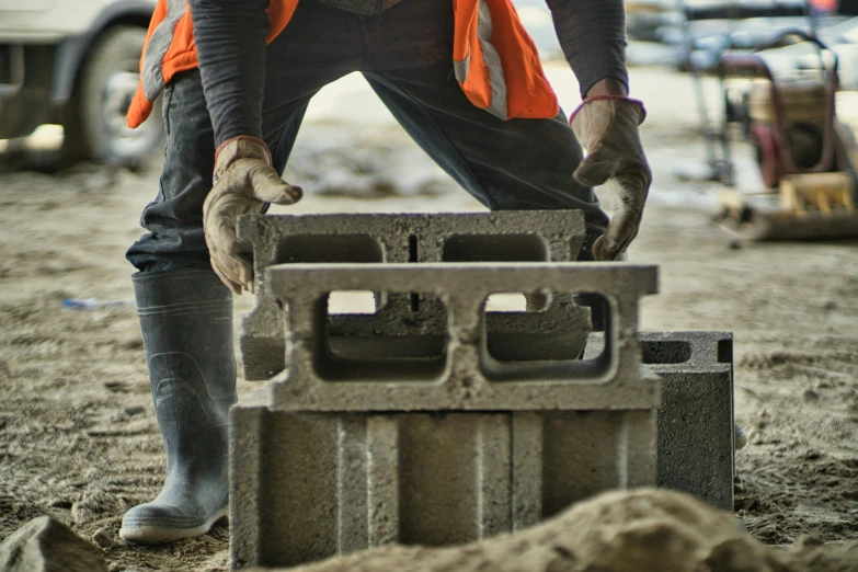 a person is using cement blocks to make a statue