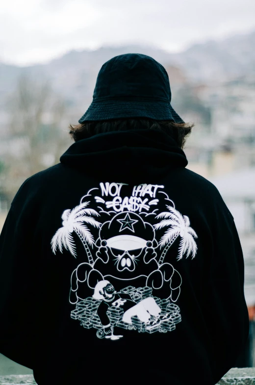 person wearing a hoodie with a white image of a cat