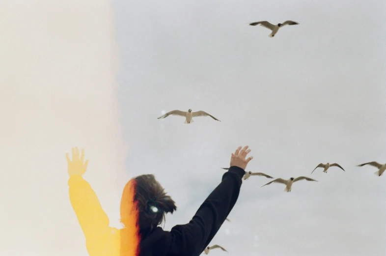 a woman in black jacket flying some birds
