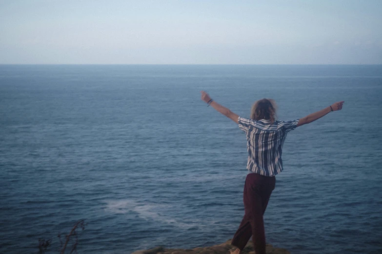 a person standing on top of a hill near the ocean