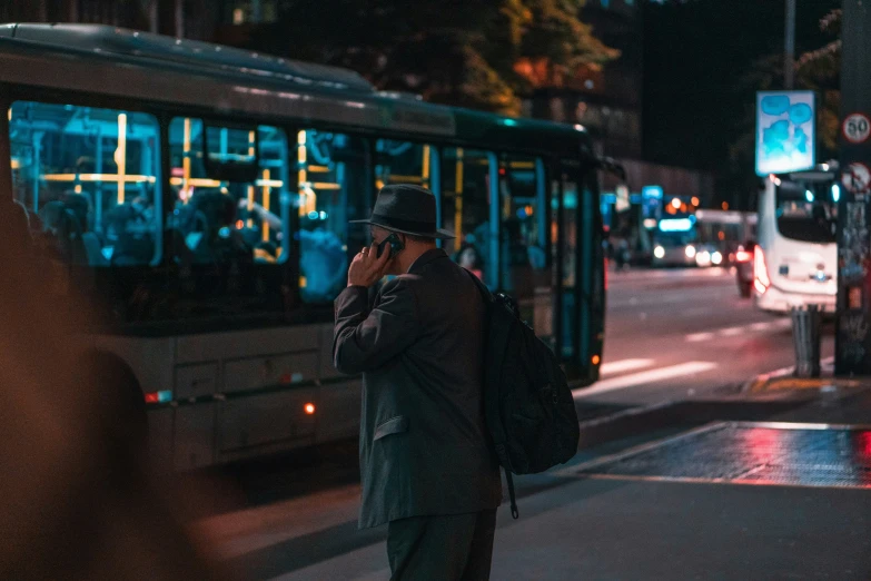 a man on his cell phone near a bus