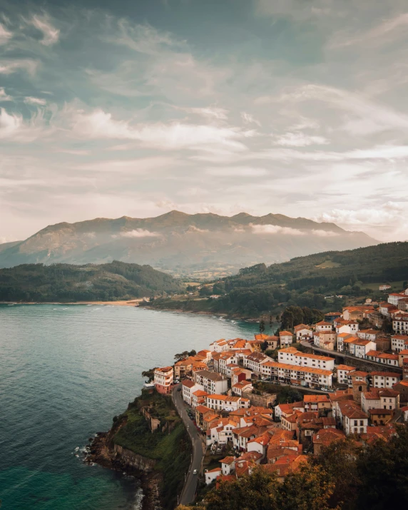 view over the town from a cliff overlooking a bay and mountains