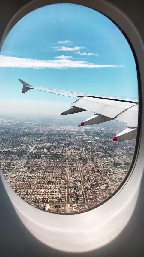 looking out of the window of an airplane at the city below